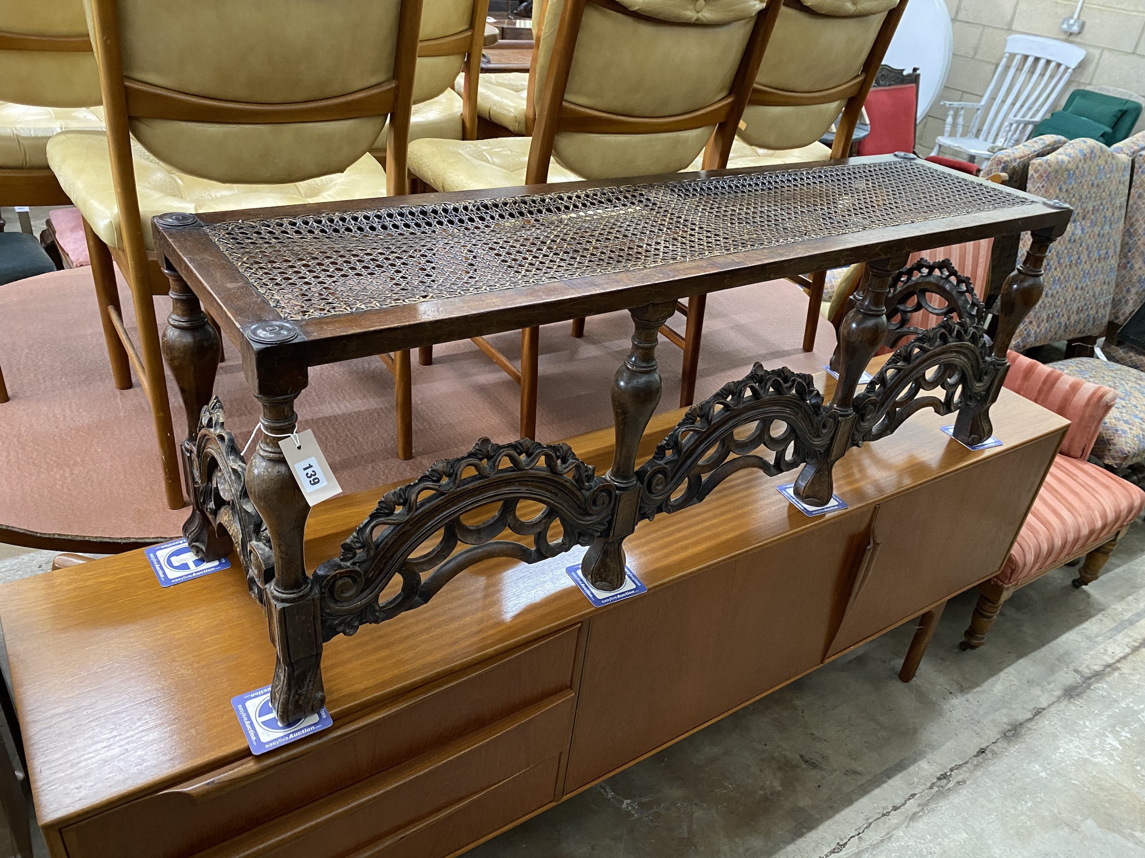 A Jacobean Revival caned carved oak window seat, width 245cm, depth 38cm, height 50cm